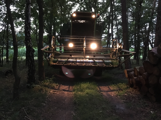 Mulcharbeiten auf einer Freifläche mit Traktor und Anbaugerät.