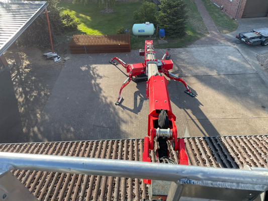 Blick von oben auf Raupen-Arbeitsbühne und Hof